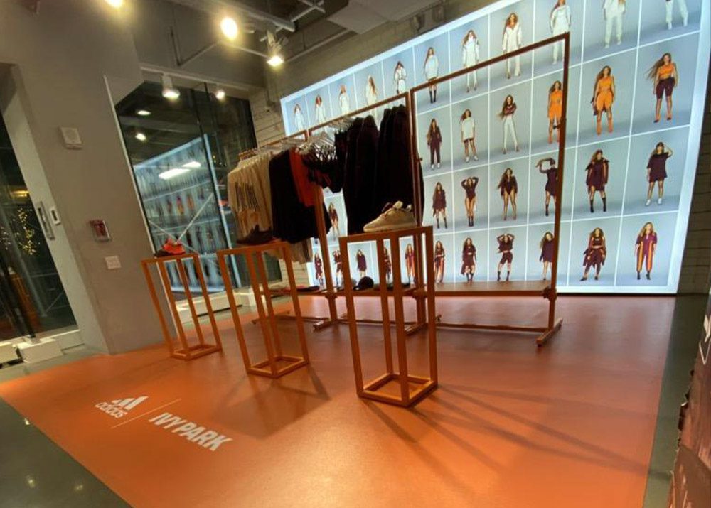 clothing store display assembled by professional retail fixture installer with light up photo display in background