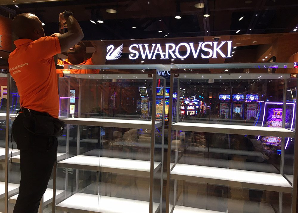 jewelry store display kiosk in casino in the process of being assembled by man in orange shirt