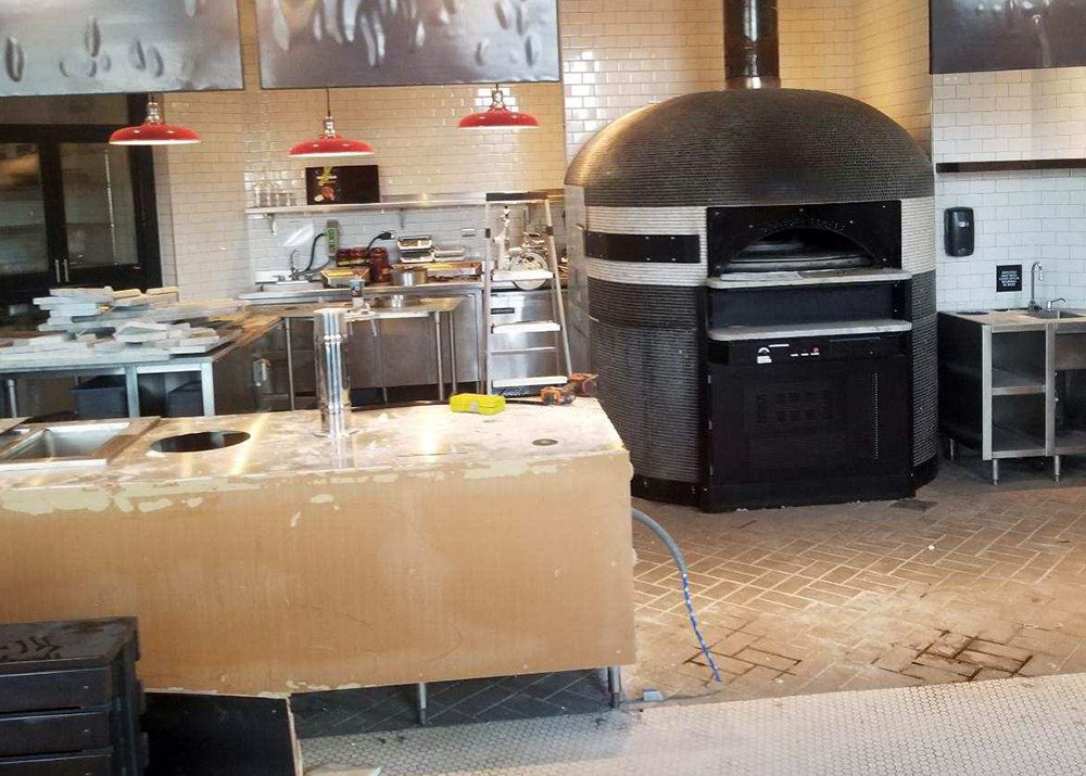 pizza oven behind counter that appears to be under contruction