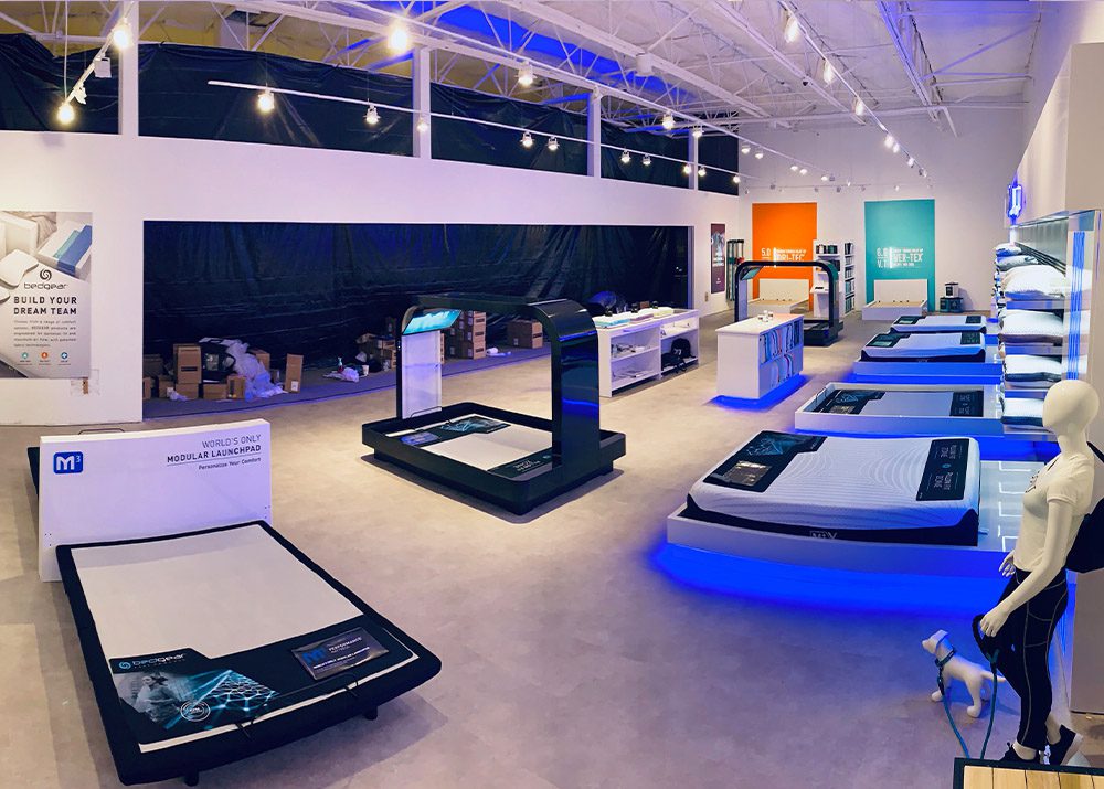 bedding and mattress store showroom setup blue led lighting throughout