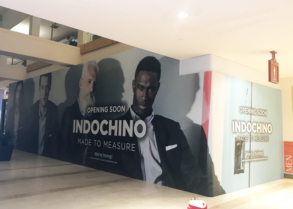 wall wrap installation on the outside of a menswear retail store in a shopping mall indicating opening soon