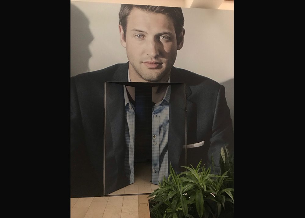 wall wrap installation on the outside of a retail store in a shopping mall showing a man in a blue blazer and button shirt