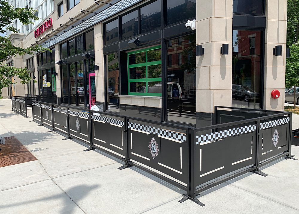black metal outdoor seating barrier with restaurant logo applied