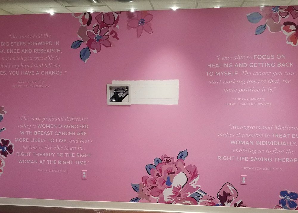 pink vinyl wall covering installation with inspirational quotes and flowers